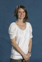Dr Lucy Fraser in the NLa studio in fron o a blue background. Lucy is wearing a white top