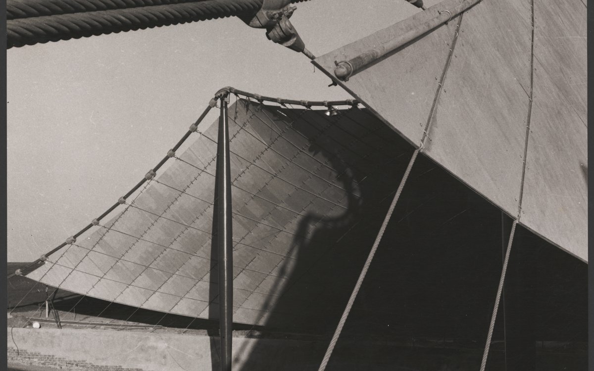 An abstract photograph of the Sidney Myer Music Bowl showing the steel cable supports holding up the sail like roof