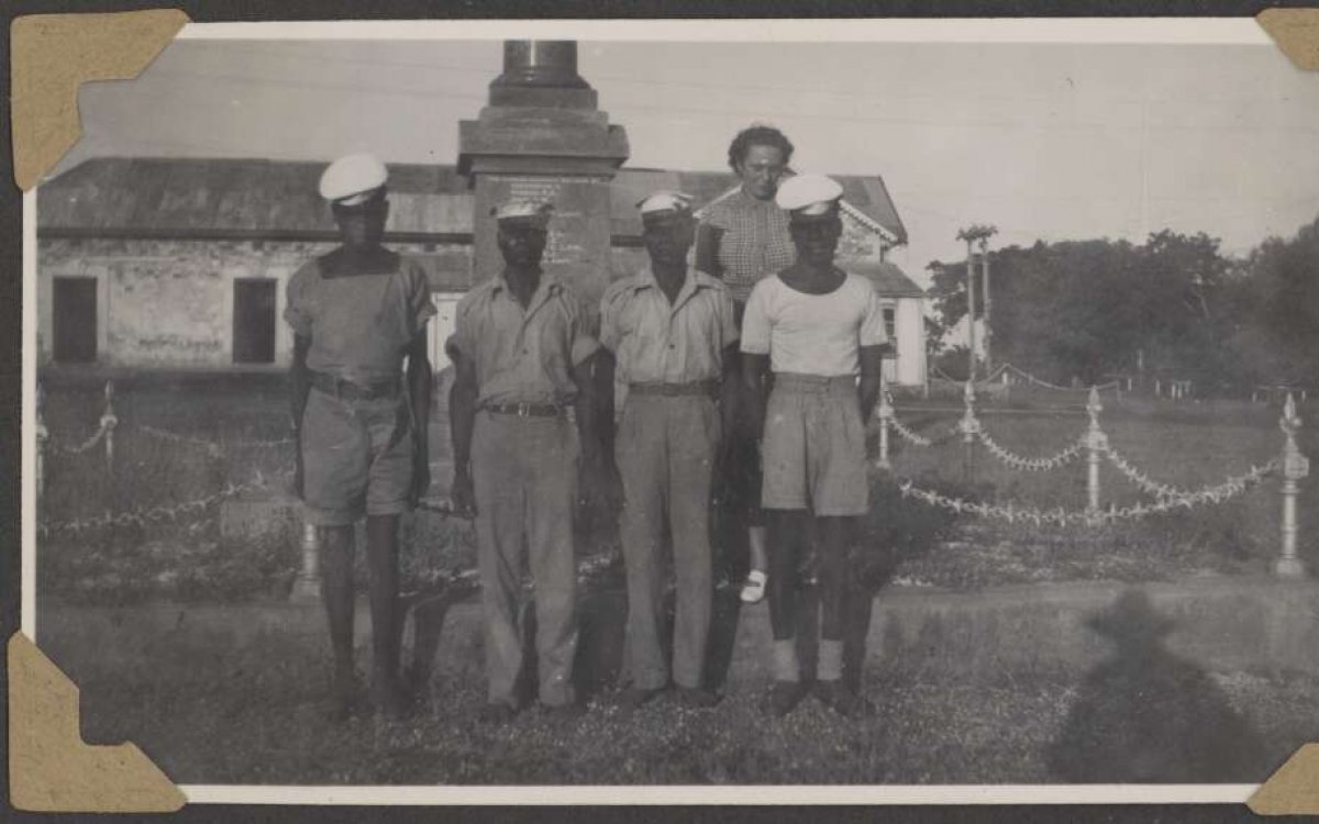 A group of Aboriginal men in military uniform stand outside a property