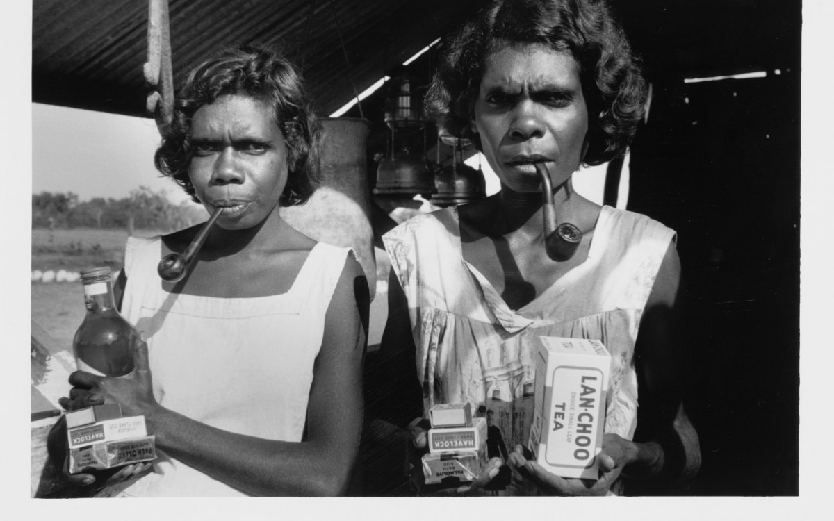 black and white photograph of two young Aboriginal women with pipes and groceries
