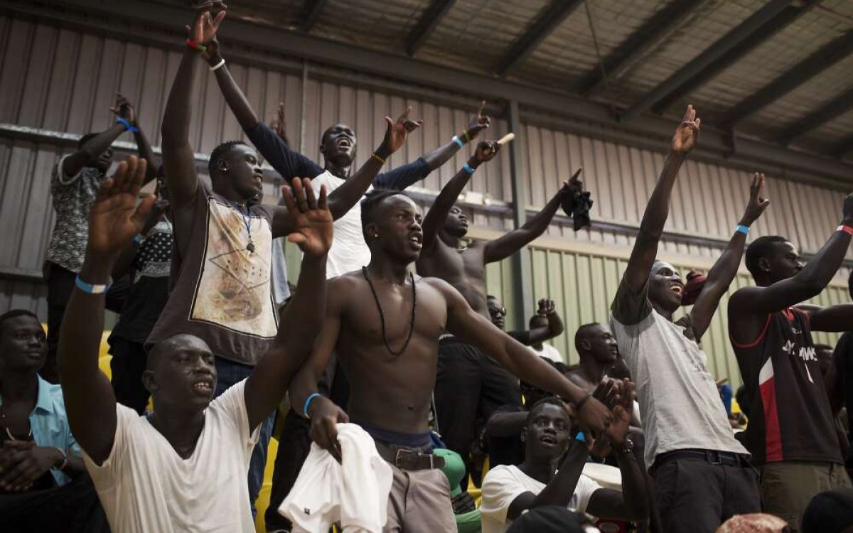 Photo of Australian South Sudanese men watching and cheering 