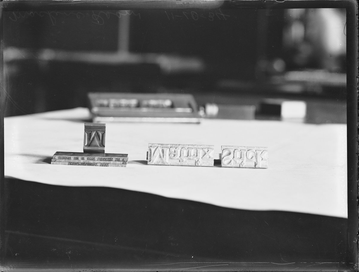 A black and white image of type letters on a piece of paper. The letters spell out "Matrix Stick" backwards and upside down.