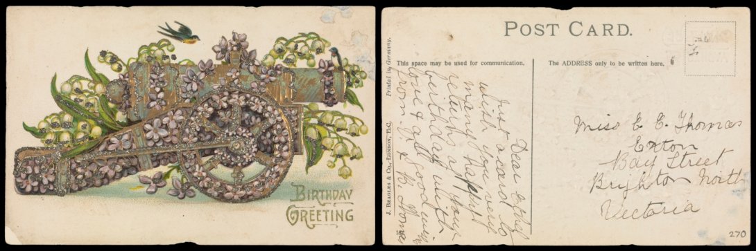 Front and back of an old postcard. On the front is the text 'is an illustration of a cannon surrounded by purple and green flowers and the text 'Birthday Greetings'. On the back is a message wishing the recipient many happy returns.