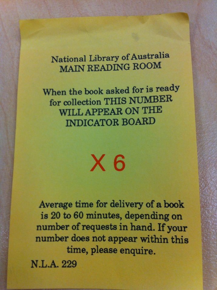 A printed sign on yellow paper asked readers to wait for their number to be displayed