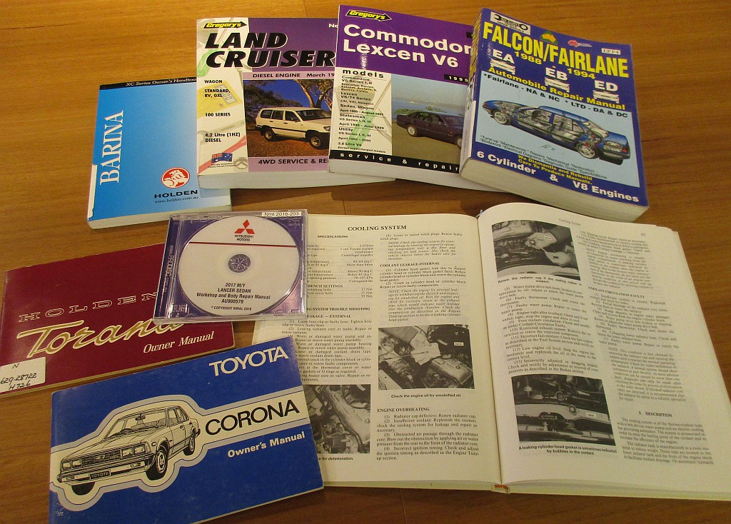 Several car manuals spread out on a table