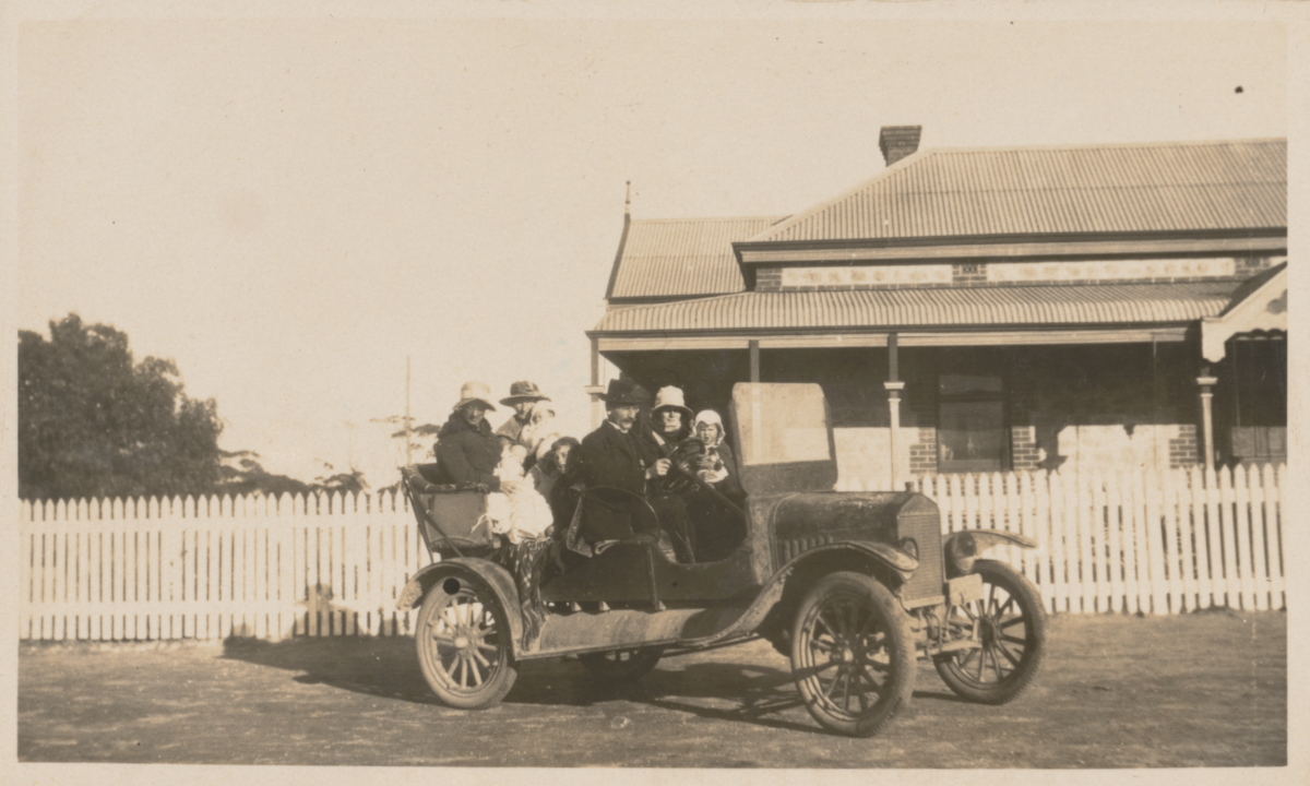 A family out for a drive in a car between 1920 and 1930