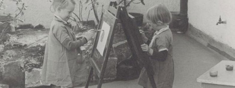 Two children painting on a easel