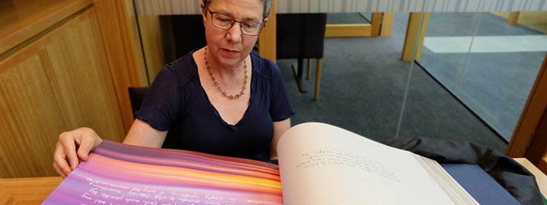 Director-General of the National Library of Australia, Marie-Louise Ayres reading the book 'Message to Australia'