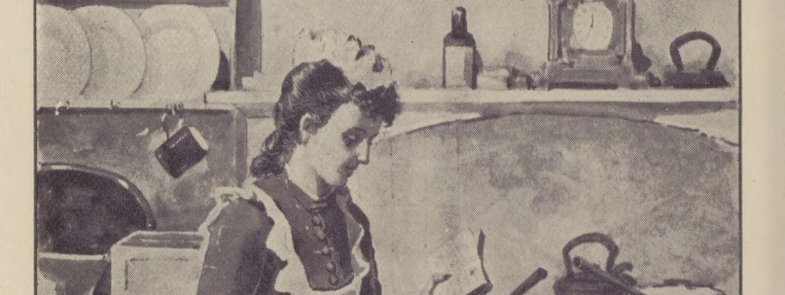 A woman stands in the centre of a kitchen looking at a cookbook.