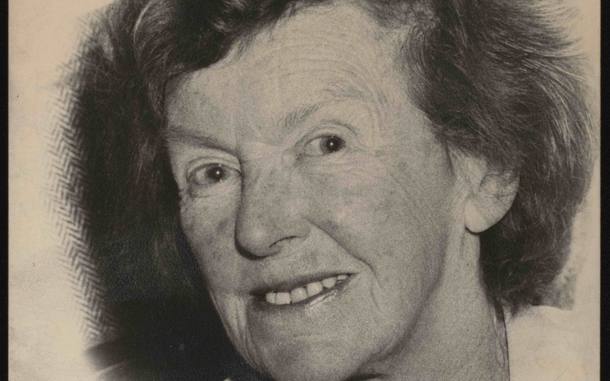 A black and white portrait photo of an elderly woman with afreckle face and red/dark coloured hair.