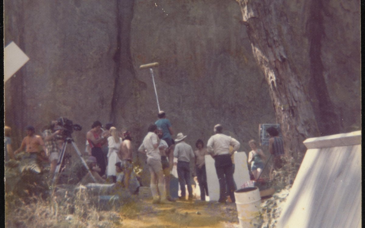 group of people filming at base of Hanging Rock from a distance