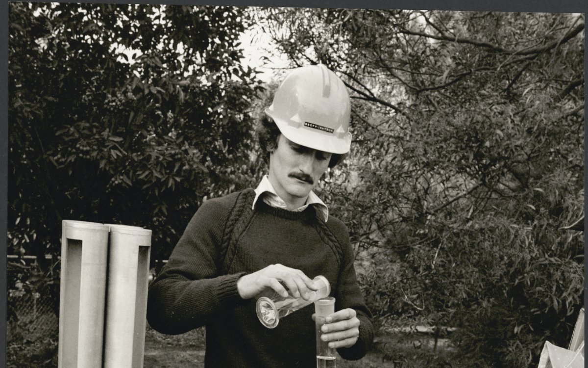 man in hardhat measuring using test tubes
