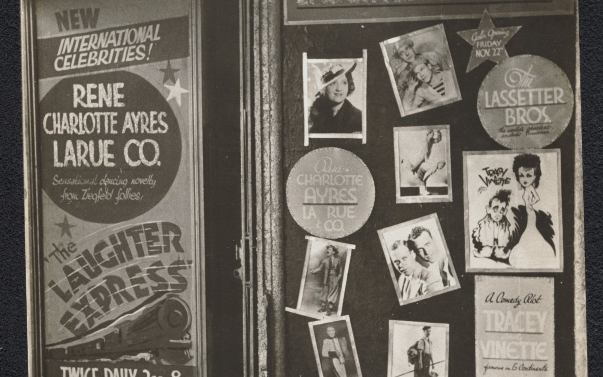 A black and white photograph of a series of billboards advertising vaudeville performances and the stars in them. One poster, for the Laughter Express, shows a steam train and the names of the performers, including Roy Rene