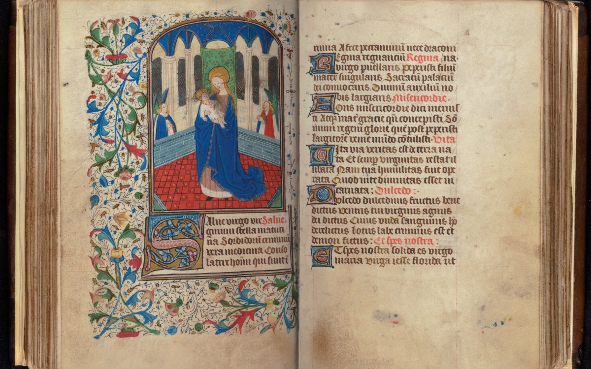 A composite image of a very old illuminated book. The left page is highly decorated and colourful. An image of a woman holding a baby is framed by plants. The right page is text written in black and red