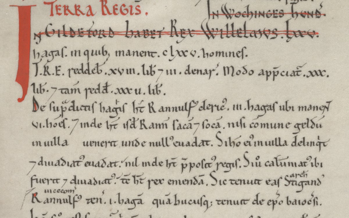 Inset from the Domesday Book. Most text is written in black ink. Some is in red. The words "Terra Regis" is written prominantly in red. The document is written in Latin and lists land owned in the county of Surrey