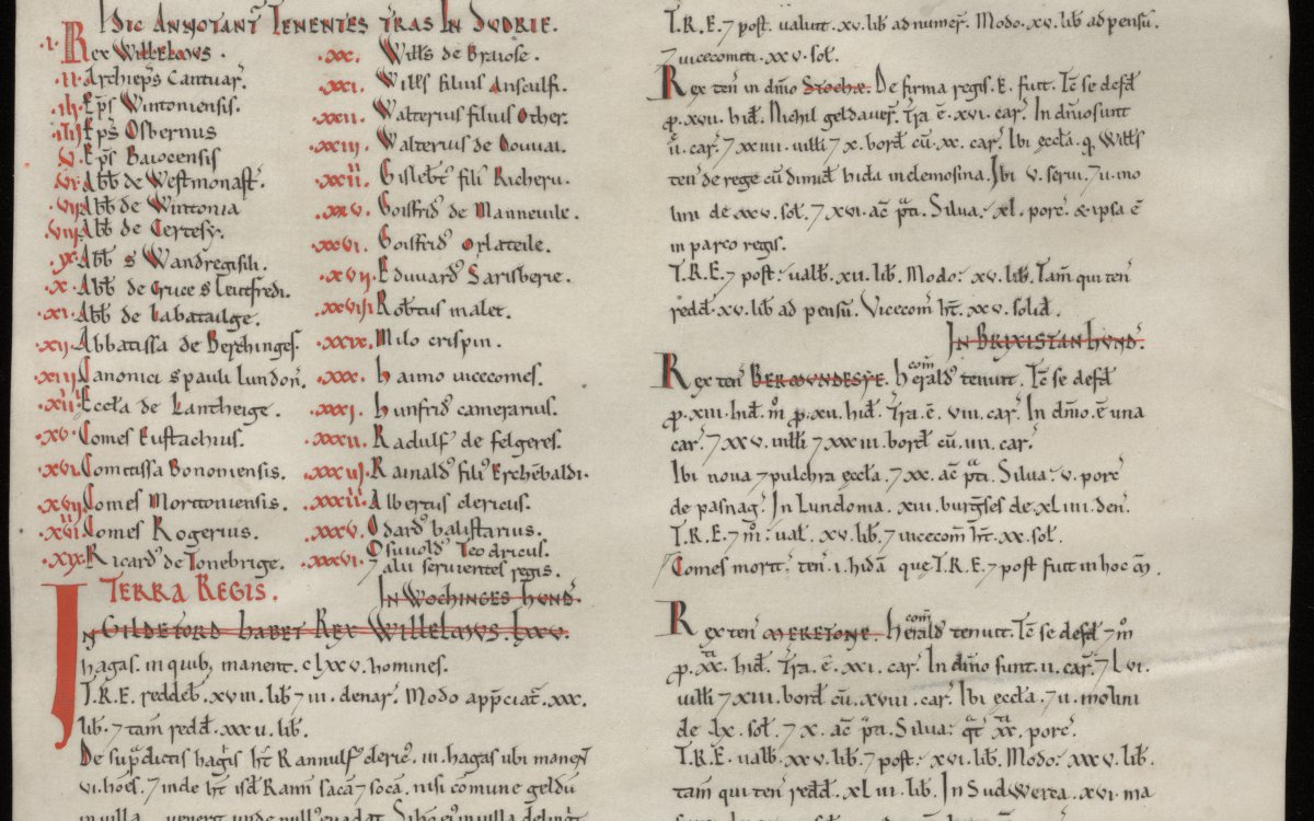 A facsimile copy of the Domesday Book. It is missing a square from the bottom left hand corner. Some of the text is black and some is red.