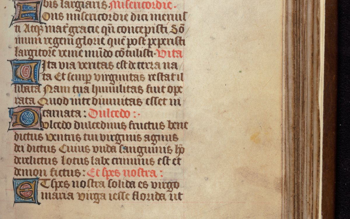 A handwritten page from a book of hours. The page is highly decorated and brightly coloured. 