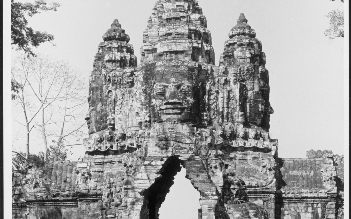A black and white photograph of Khmer Temple gate surrounded by trees