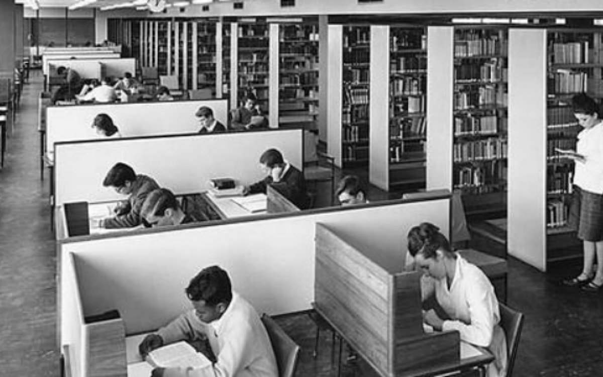 Students in desks and browsing library shelves in Monash University Library