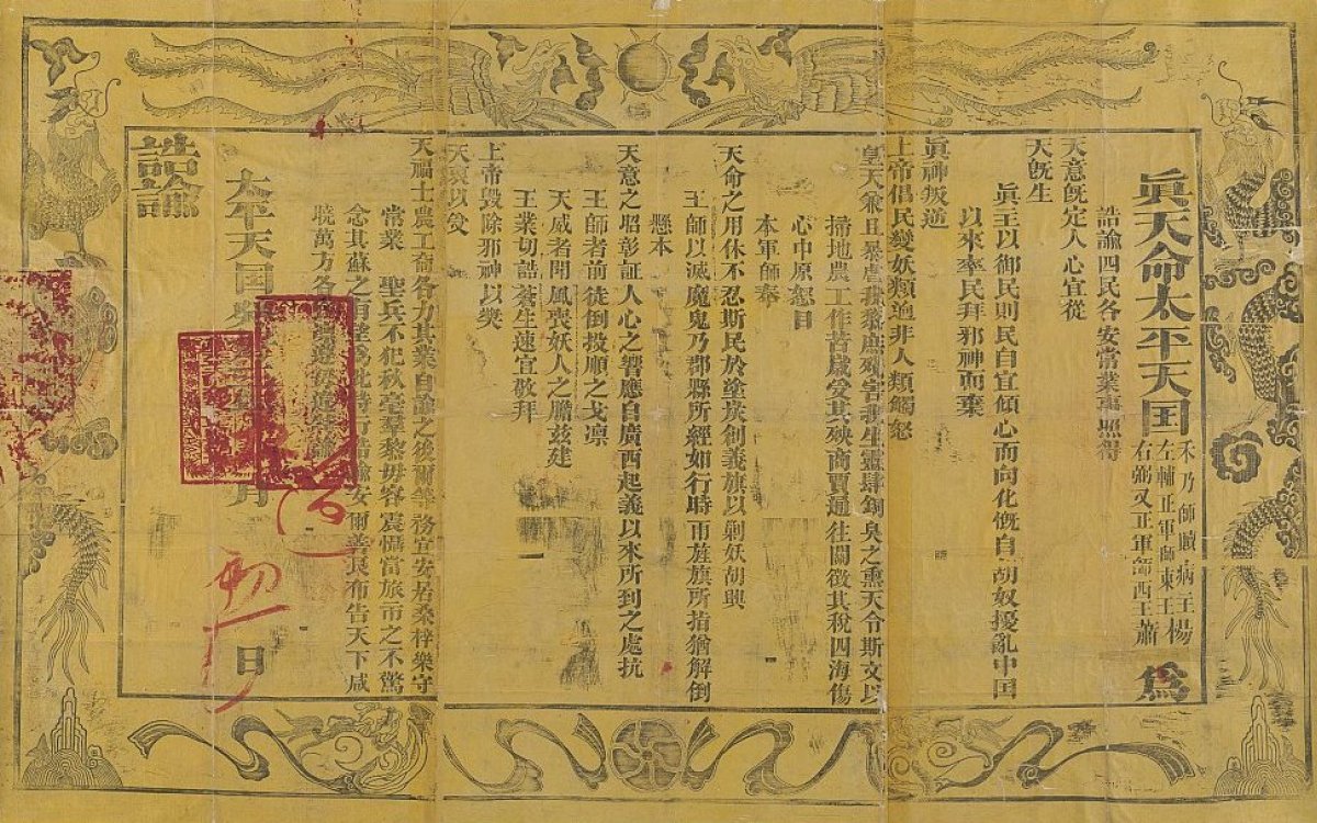 A yellowed piece of decorated parchment with Chinese writing and red stamps.
