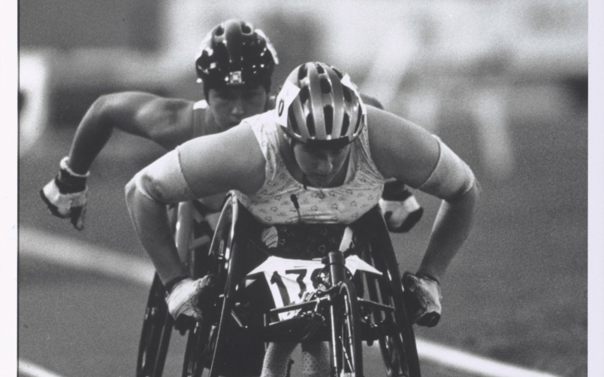 Black and white photo of Louise Sauvage and another woman racing in wheelchairs