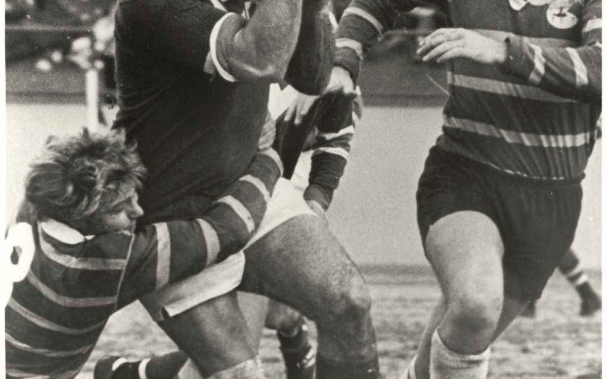 Black and white photo of Rugby League player, Arthur Beetson, looks for a team mate before passing the ball