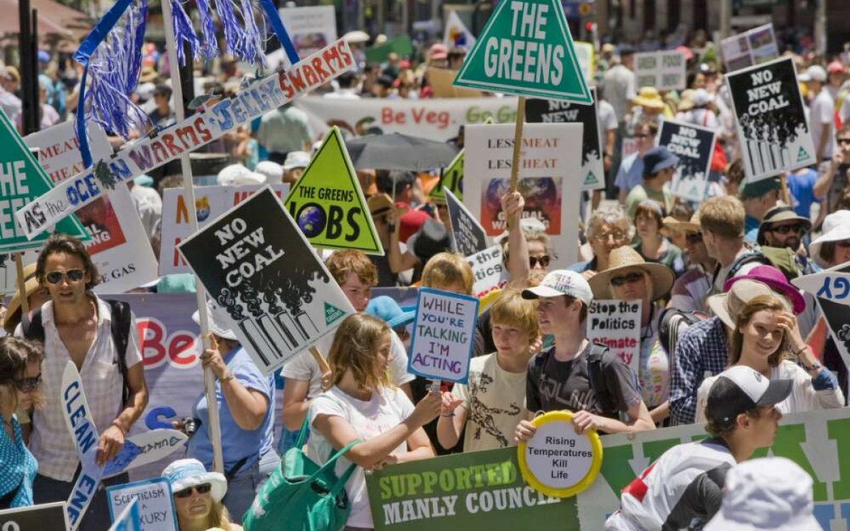 Photo of a large crowd with placards against global warming.