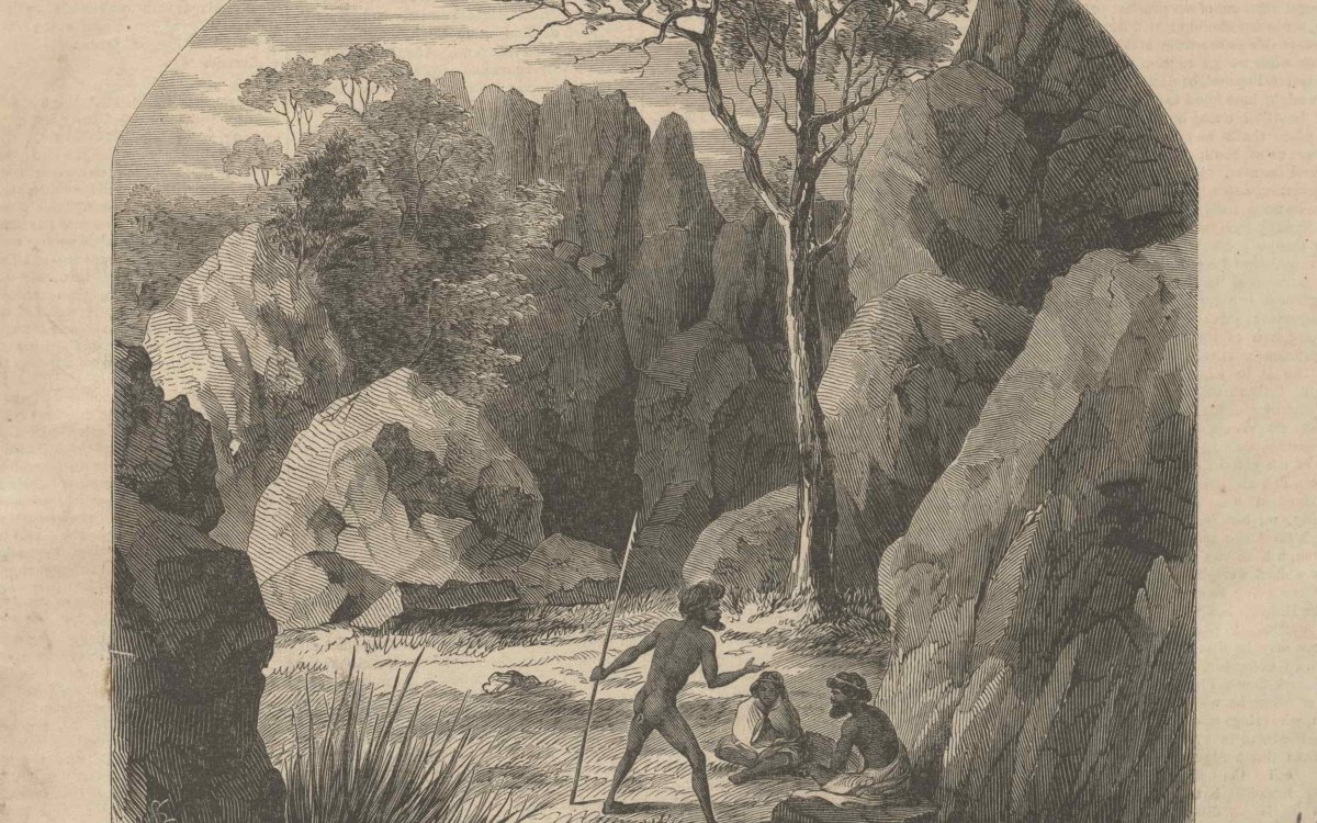 A black and sepia toned wood engraving of an Indigenous man holding a spear resting on the ground while talking animatedly to another Indigenous man and woman sitting on the ground amongst tall boulders, grasses, shrubs and trees.