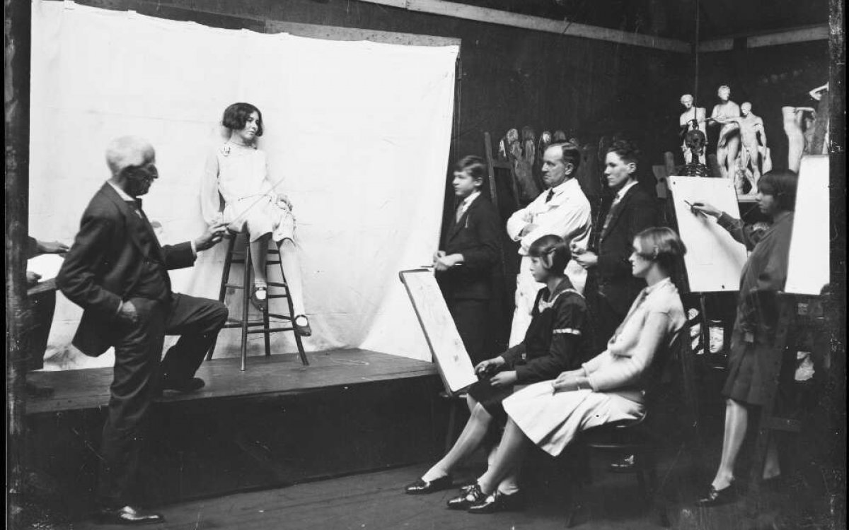 black and white photograph of a group of young women drawing a model