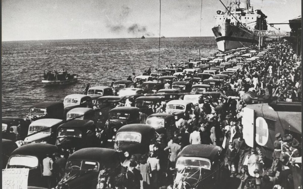 black and white photograph of rows of cars on the dockside ready to pick up returning prisoners of war