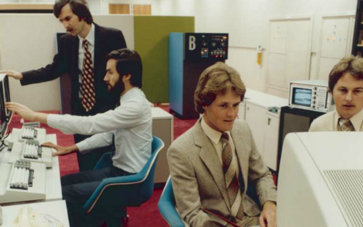 Four men using computers in an office