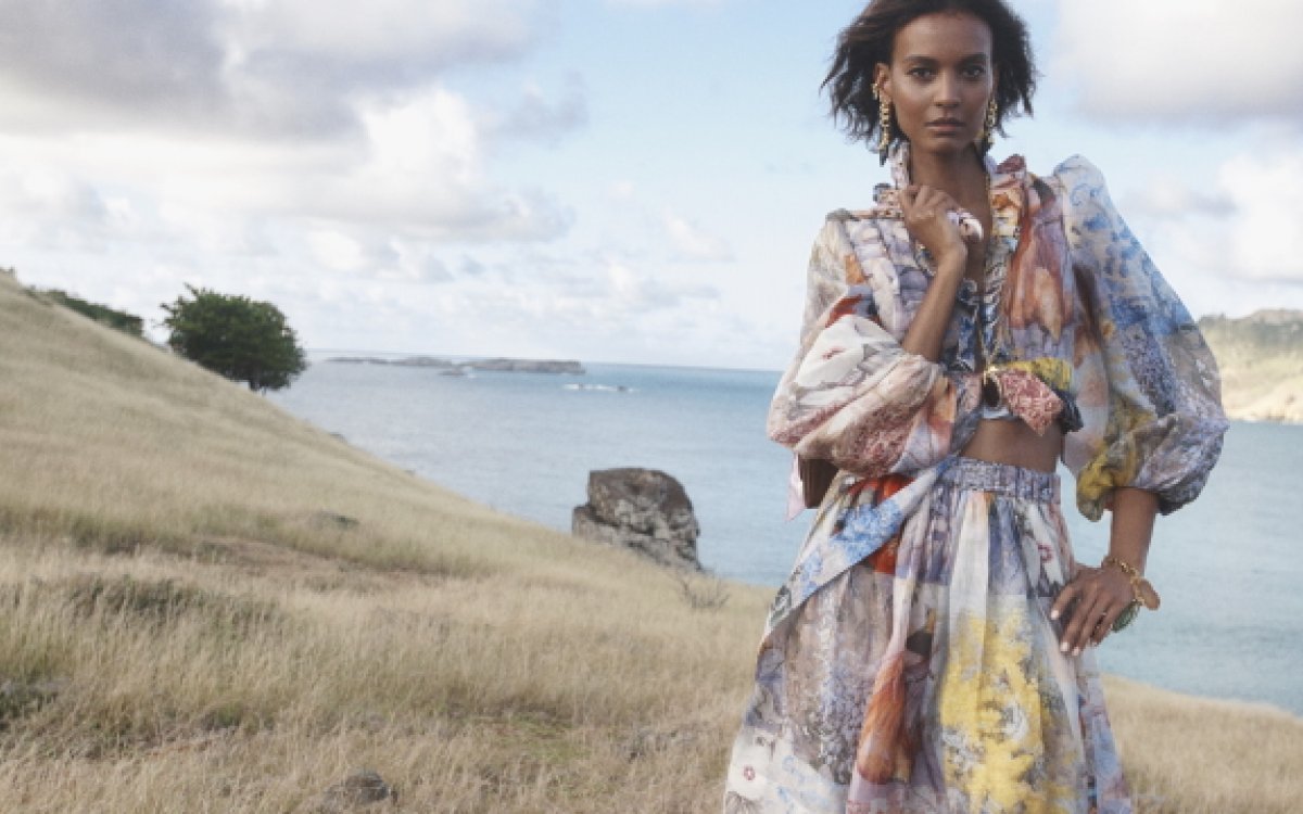 A model wearing a look from Zimmermann's Spring 21, Wild Botanica, collection standing on a hill overlooking the sea.