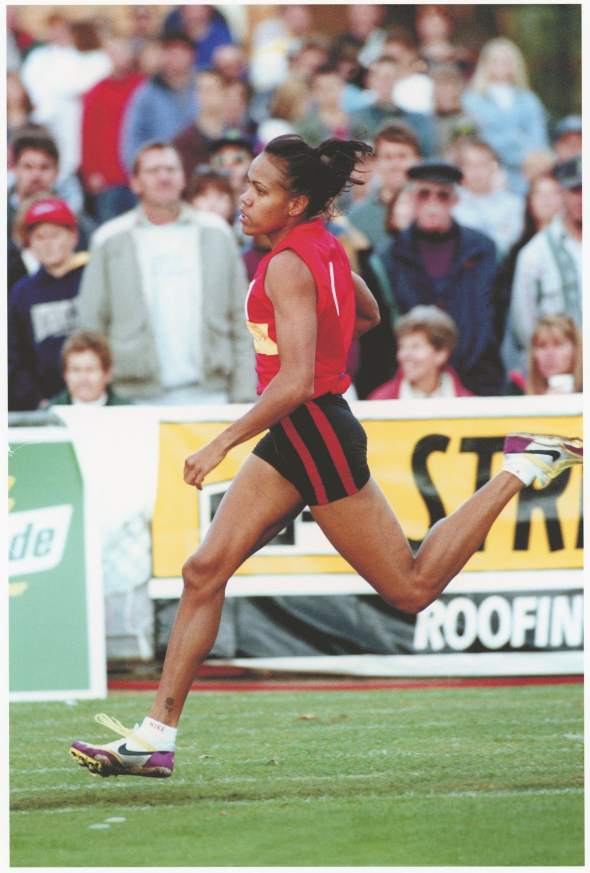 Photo of Cathy Freeman running in front of a crowd at a sport stadium