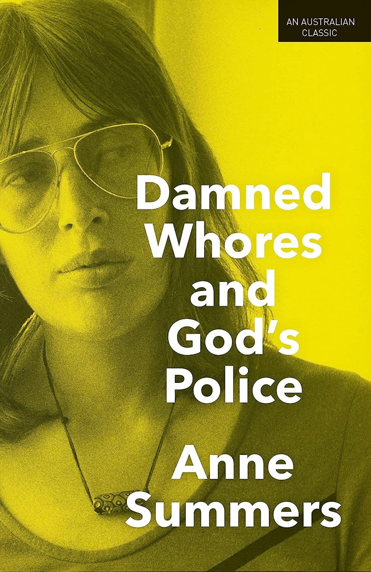 The front cover of a book. It is yellow and grey. A woman wearing large glasses looks off camera. The title of the book reads "DAMNED WHORES AND GOD'S POLICE - ANNE SUMMERS"