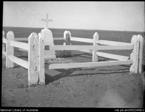 Unidentified grave surrounded by a white wooden fence