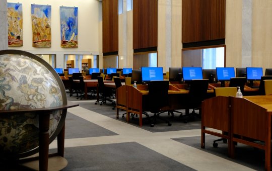 Rows of desks and computers in the Library's Main Reading Room. A large globe is in the foreground.