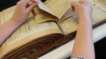 Conservator examining theatre scrapbooks