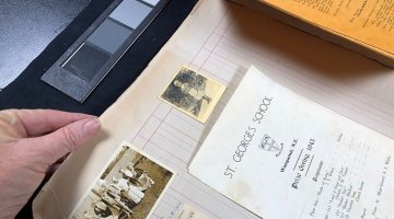 Digitisation staff examining photographs in theatre scrapbooks