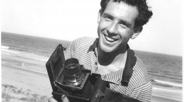 A young Frank Hurley holding a camera