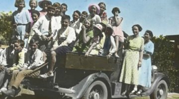 Group of children and two women standing on tray of car