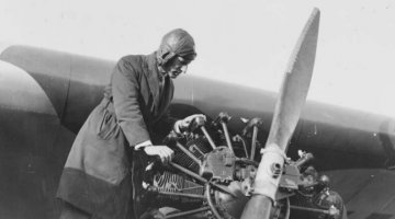 Charles Kingsford Smith examining the propeller of a plane