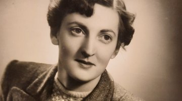 A sepia portrait of a women with short hair, wearing a jumper and a blazer over the top,