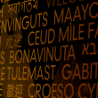 Words in different languages in yellow text on a black background
