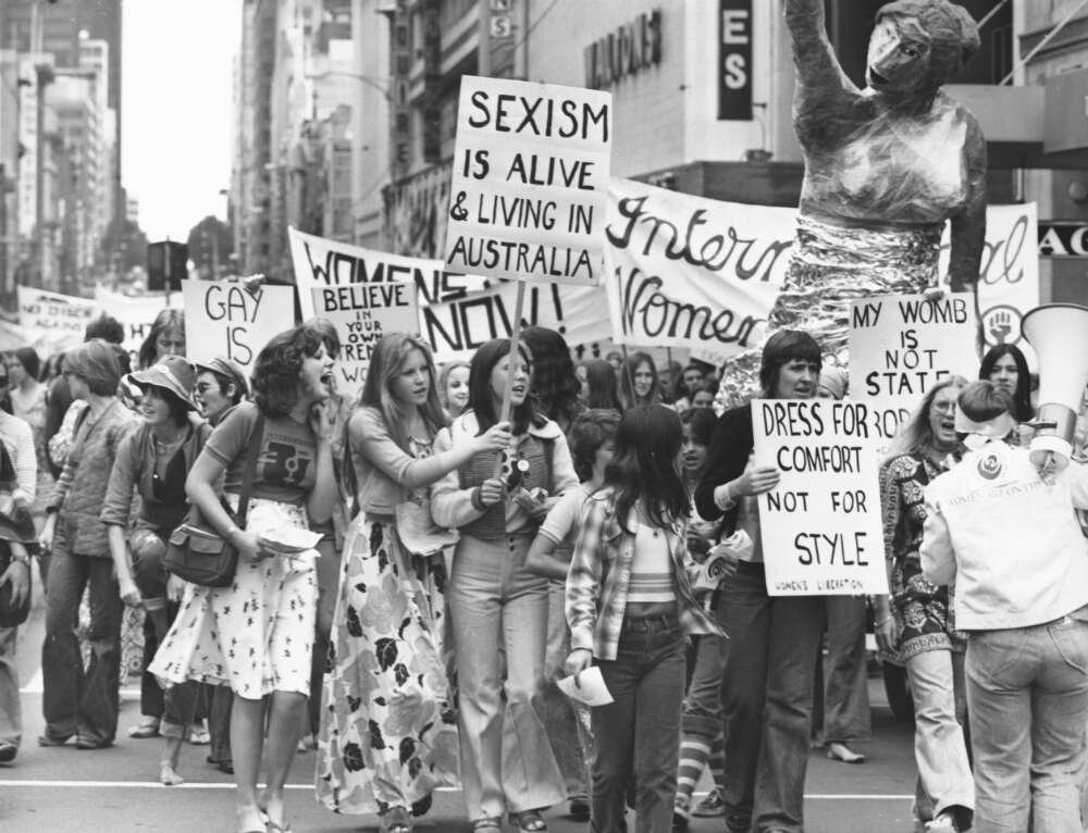 A protest march with women holding feminist protest signs