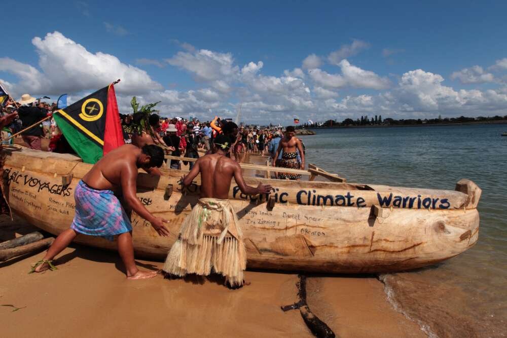 Members of the Pacific Climate Warriors prepare to launch canoes into the Port of Newcastle.