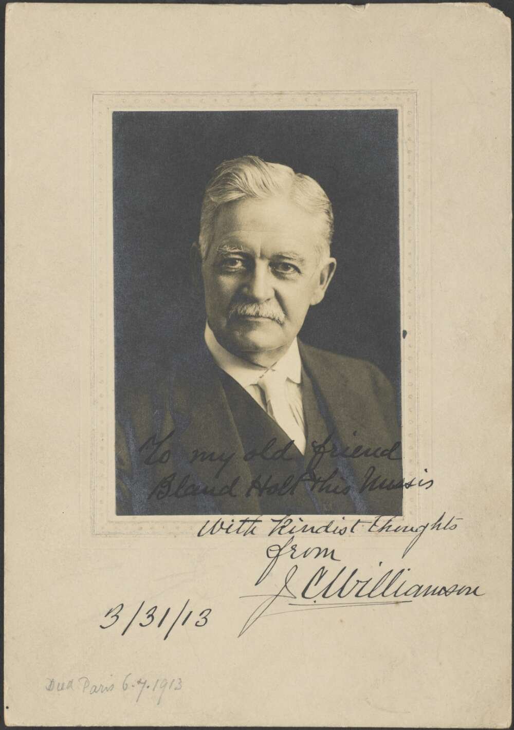 Black and white portrait photograph of a man looking directly at the camera. The photograph is signed and dated March 1913
