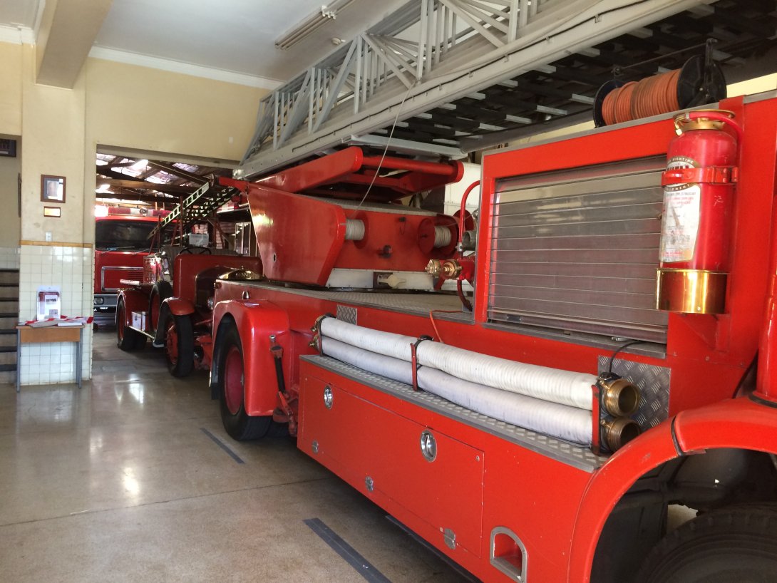 A red firefighting vehicle is parked in an indoor parking bay