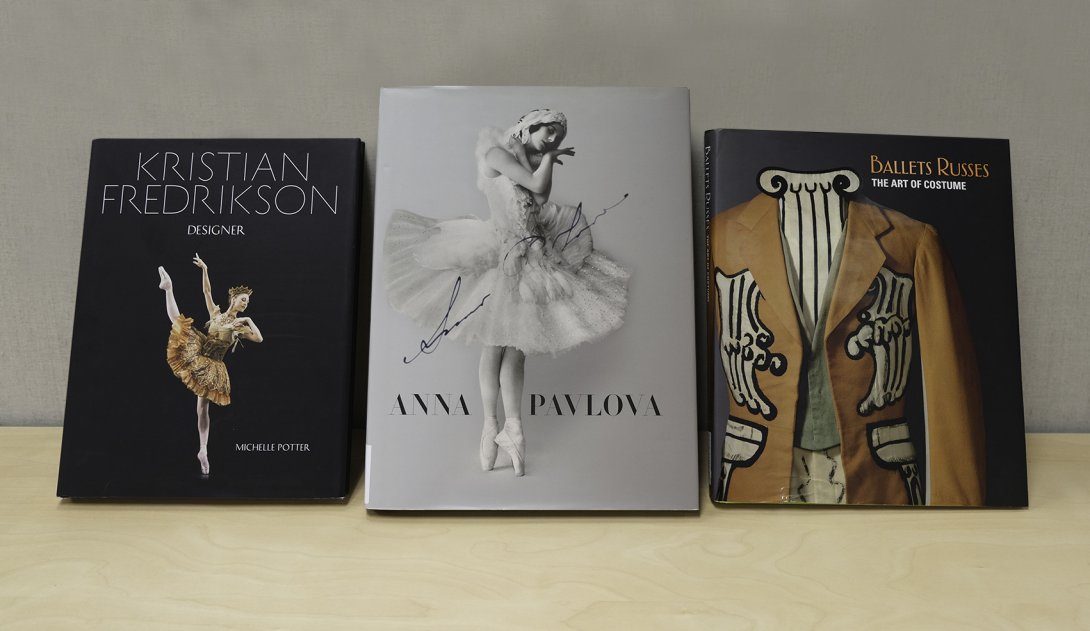 Book cover featuring a ballerina on a dark background; book cover featuring a ballerina in white on a light background; book cover featuring a close up of an embroidered stage costume