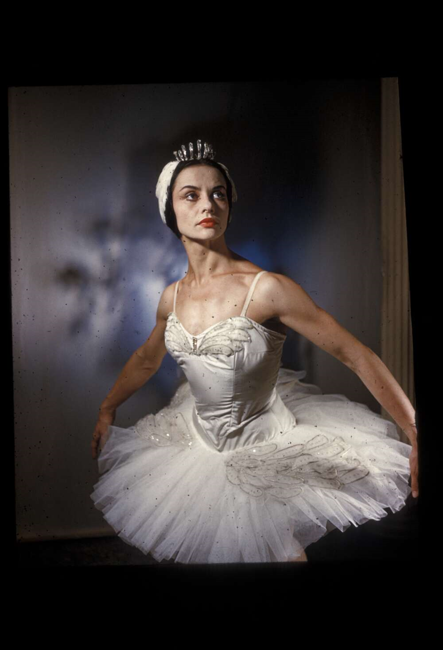 Photograph of a woman in a white Swan Lake costume, striking a ballet pose