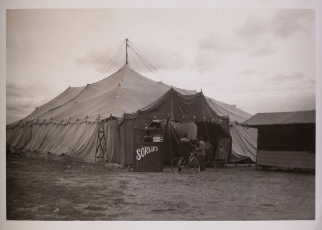 A photograph of the outside of a theatre tent with a sign saying ‘Sorlie’s’
